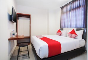 A hotel room with a bed, a desk, a chair, a TV, and a window with curtains. - Hotel O Genteng Near Genteng Market Formerly Uno Hotel (Surabaya)
