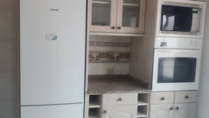 A kitchen with a Siemens refrigerator, a microwave, and an oven. - 1A135 Comodo Apto 3 dormitorios (Gijón)