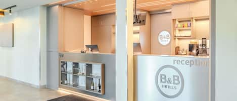 Ein Empfangsbereich mit Rezeption, einer Minibar und einer Kaffeemaschine.