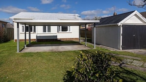 A single-story house with a covered patio, a fenced yard, and a garage. - Central Villa - Character Home, Walk to CBD (Rotorua)