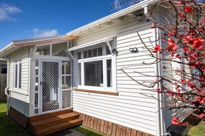 A mobile home with a screened porch and a small deck.