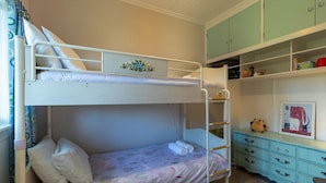 A bunk bed room with a lower bunk, a dresser with drawers, and a shelf with various items. - Central Villa - Character Home, Walk to CBD (Rotorua)