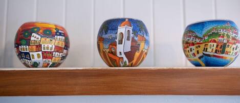 Tres cuencos de cerámica con diferentes diseños pintados sobre una estantería.