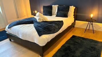Cozy retreat with a large bed, bedside table, and soft rug.