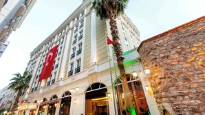 A hotel with a prominent red flag, arched windows, and a stone facade. - Baron Hotel & Spa (Istanbul)