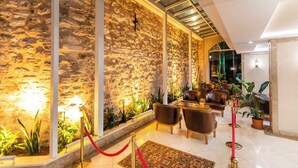 A lobby with stone walls, modern lighting, and leather seating. - Baron Hotel & Spa (Istanbul)