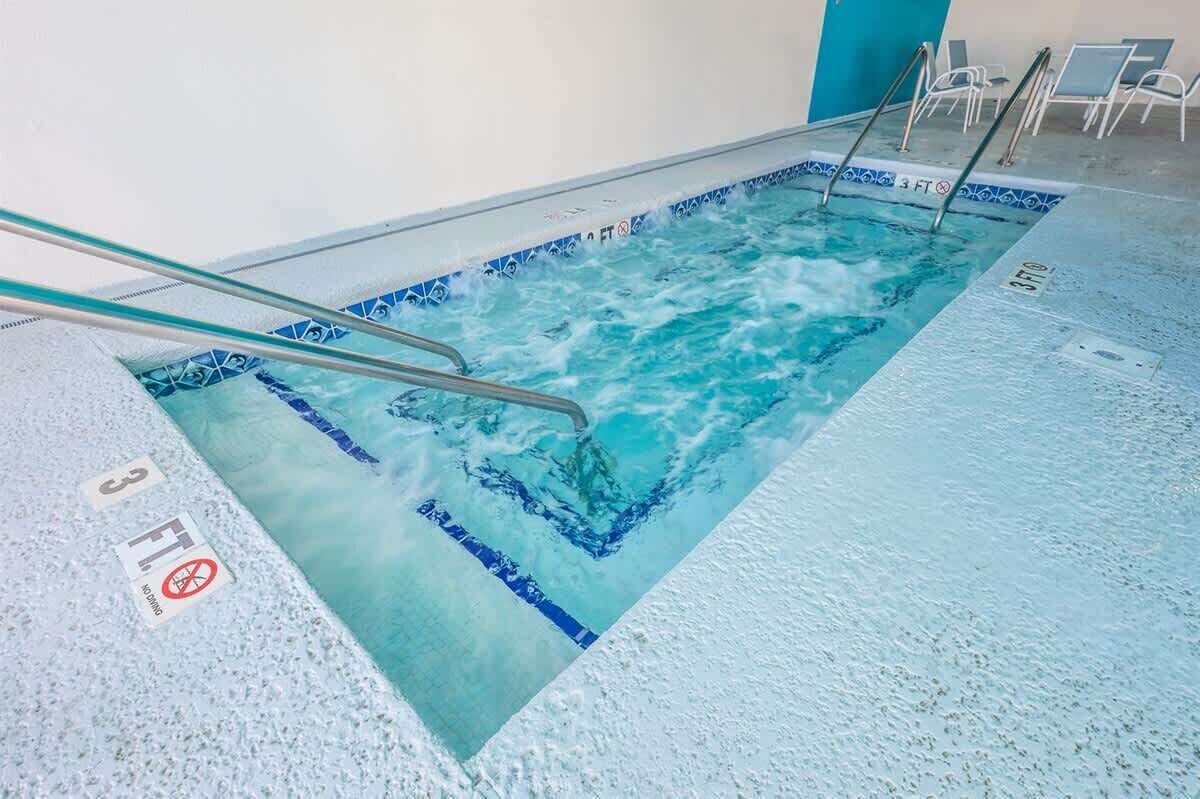 A swimming pool with a blue tiled edge, a no diving sign, and a 3 FT depth marker.