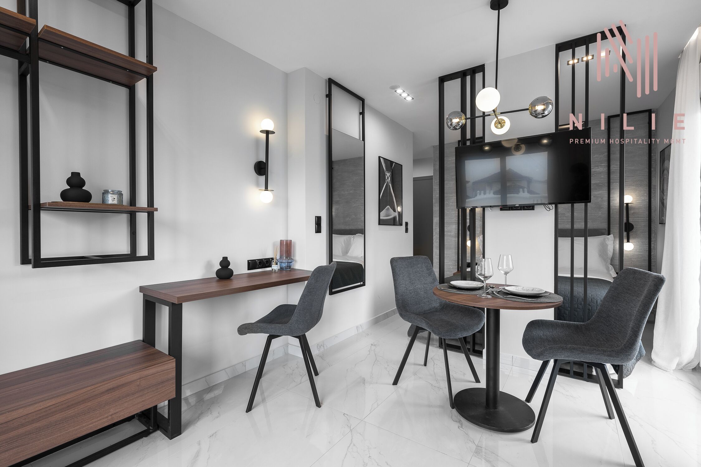 Un'area pranzo moderna con un tavolo in legno, due sedie grigie imbottite e una panca.