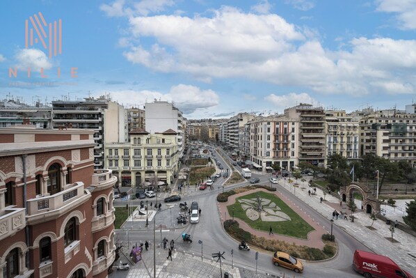 A cityscape with a prominent building featuring a large arched entrance and a central courtyard with a geometric design.