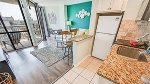 A modern kitchen with a granite countertop, a built-in sink, and a refrigerator. - New, Beautiful Decor, Meridian Plaza, Pools, Nice! (Myrtle Beach)