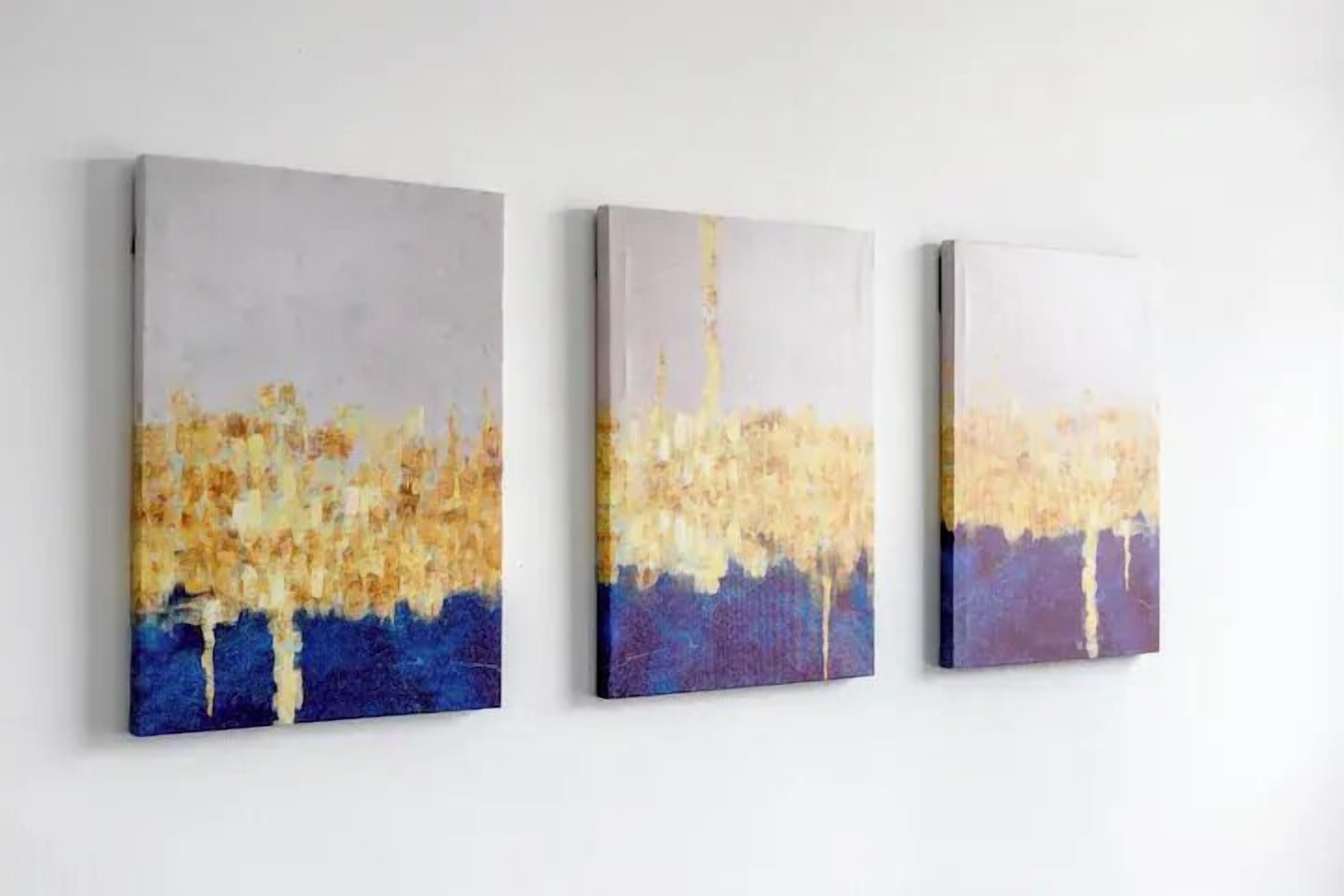 Three abstract paintings on a white wall.