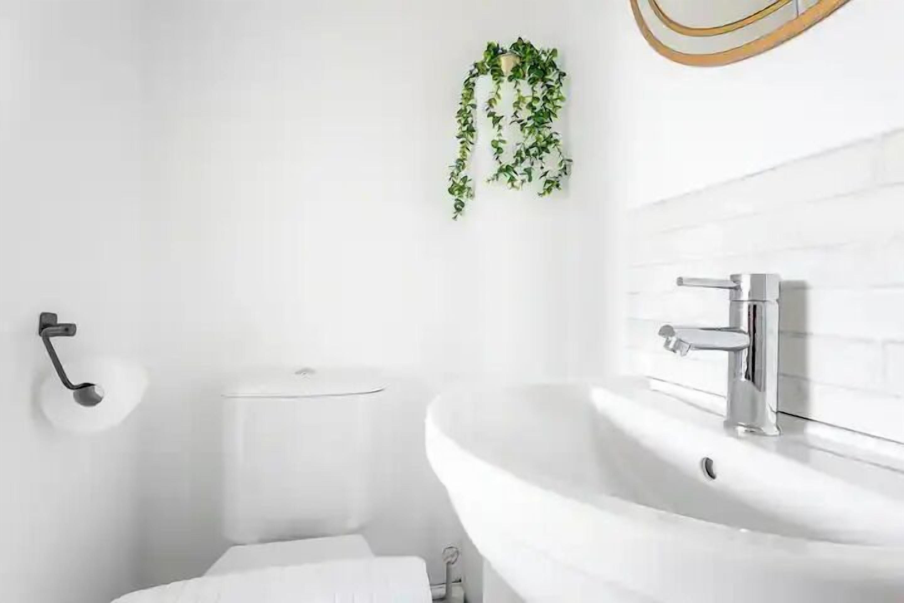 Ein modernes Badezimmer mit Waschbecken, Toilette und Toilettenpapierhalter.