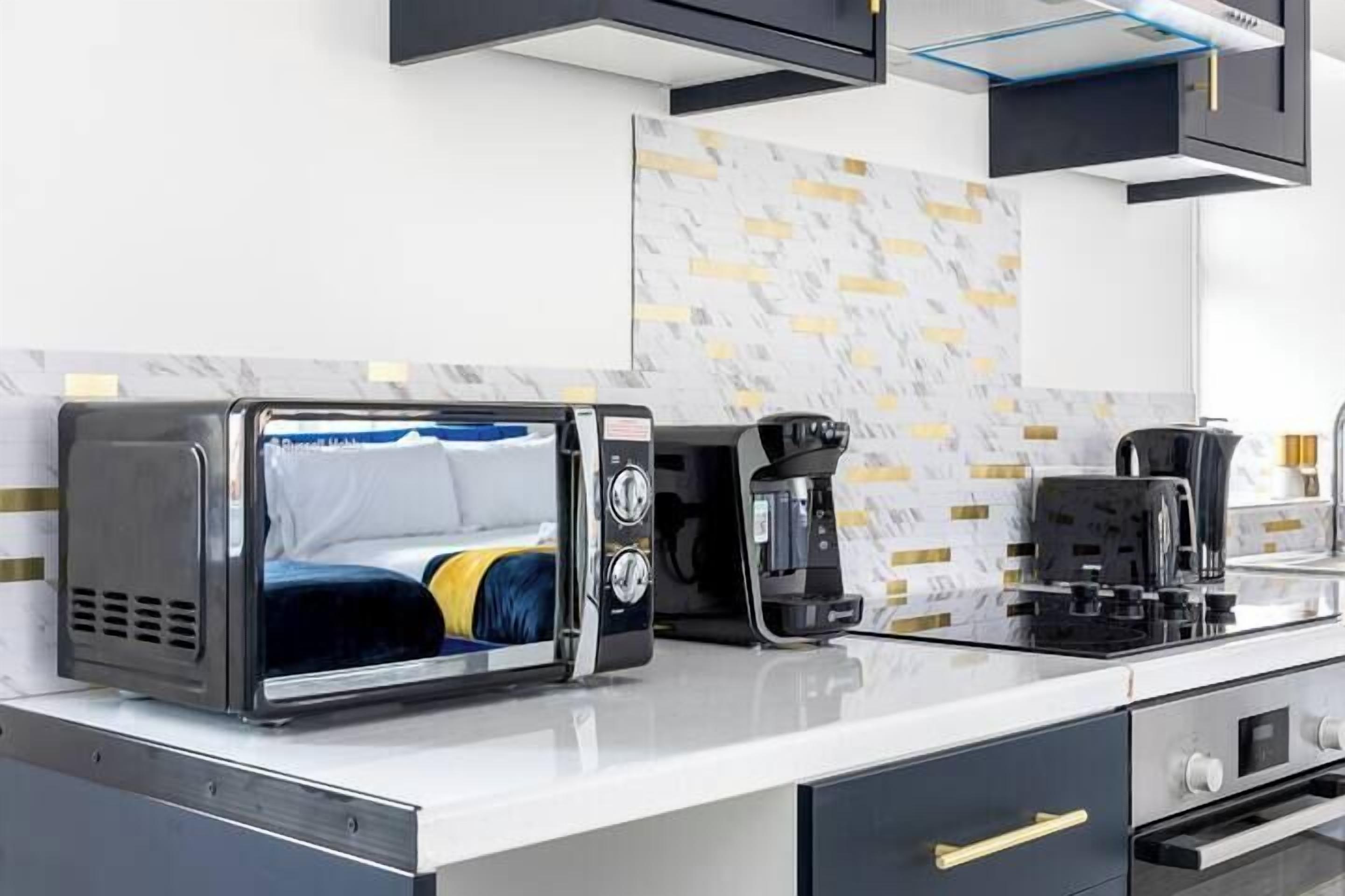 A modern kitchen with a built-in toaster, coffee maker, and oven.