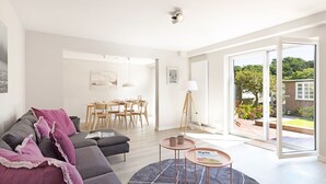 A modern living room with a sofa, coffee table, and dining area. - "Experience luxury and relaxation at the Buhne 44 vacation home on Sylt!" (List auf Sylt)