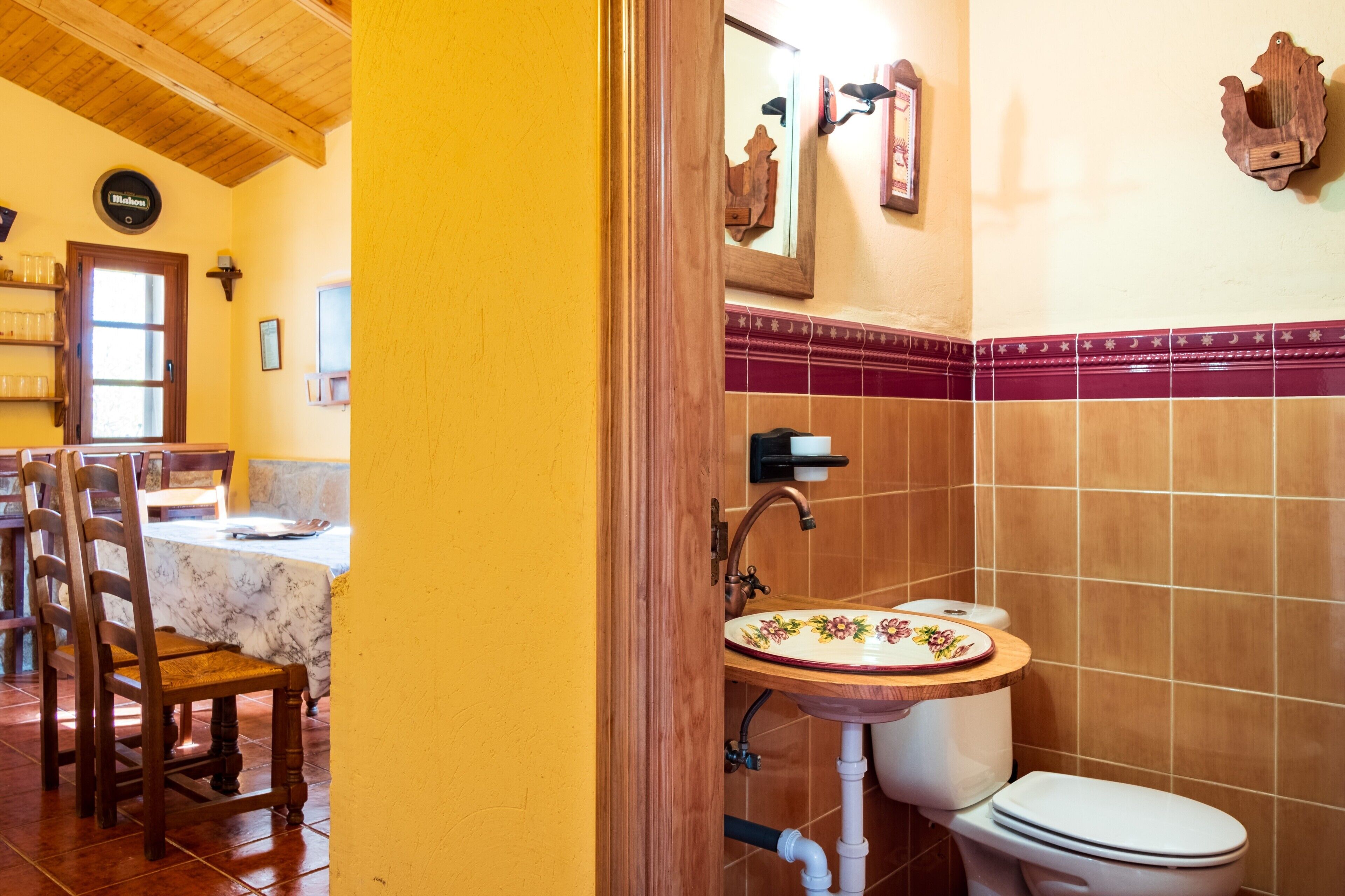 Une salle de bain avec un lavabo en bois, des toilettes et un miroir.