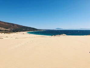 A wide sandy beach with a clear blue sea and distant mountains. - Beautiful Coastal Retreat in Punta Paloma, Tarifa (Tarifa)