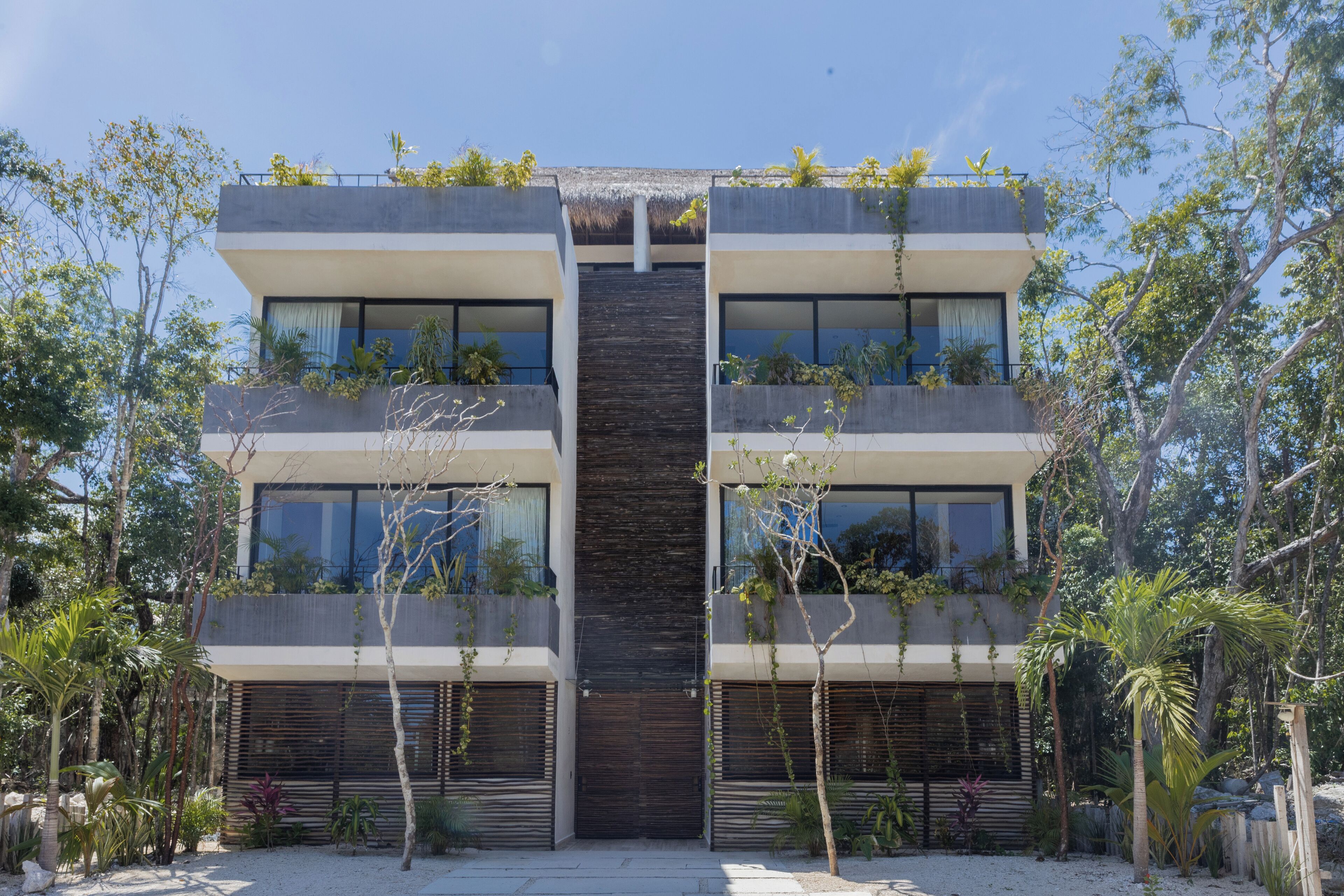 A modern two-story building with balconies, large windows, and a central entrance.
