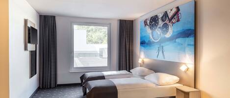 A hotel room with a bed, two bedside tables, a TV, a window, and a painting on the wall.