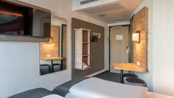 Ein modernes Hotelzimmer mit zwei Betten, einem Fernseher, einem Einbauschrank und einem Spiegel.