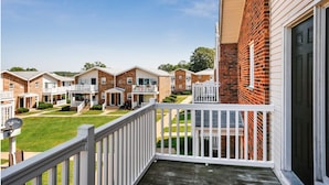 A residential building with multiple two-story houses, each with a front porch and a small front yard.