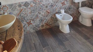 Une salle de bain équipée d’un lavabo, d’un bidet, de toilettes et de carreaux décorés.