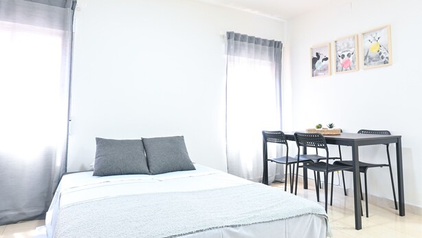 A bedroom with a bed, a desk, and chairs. - Cozy Apartment in Vallecas (Madrid)