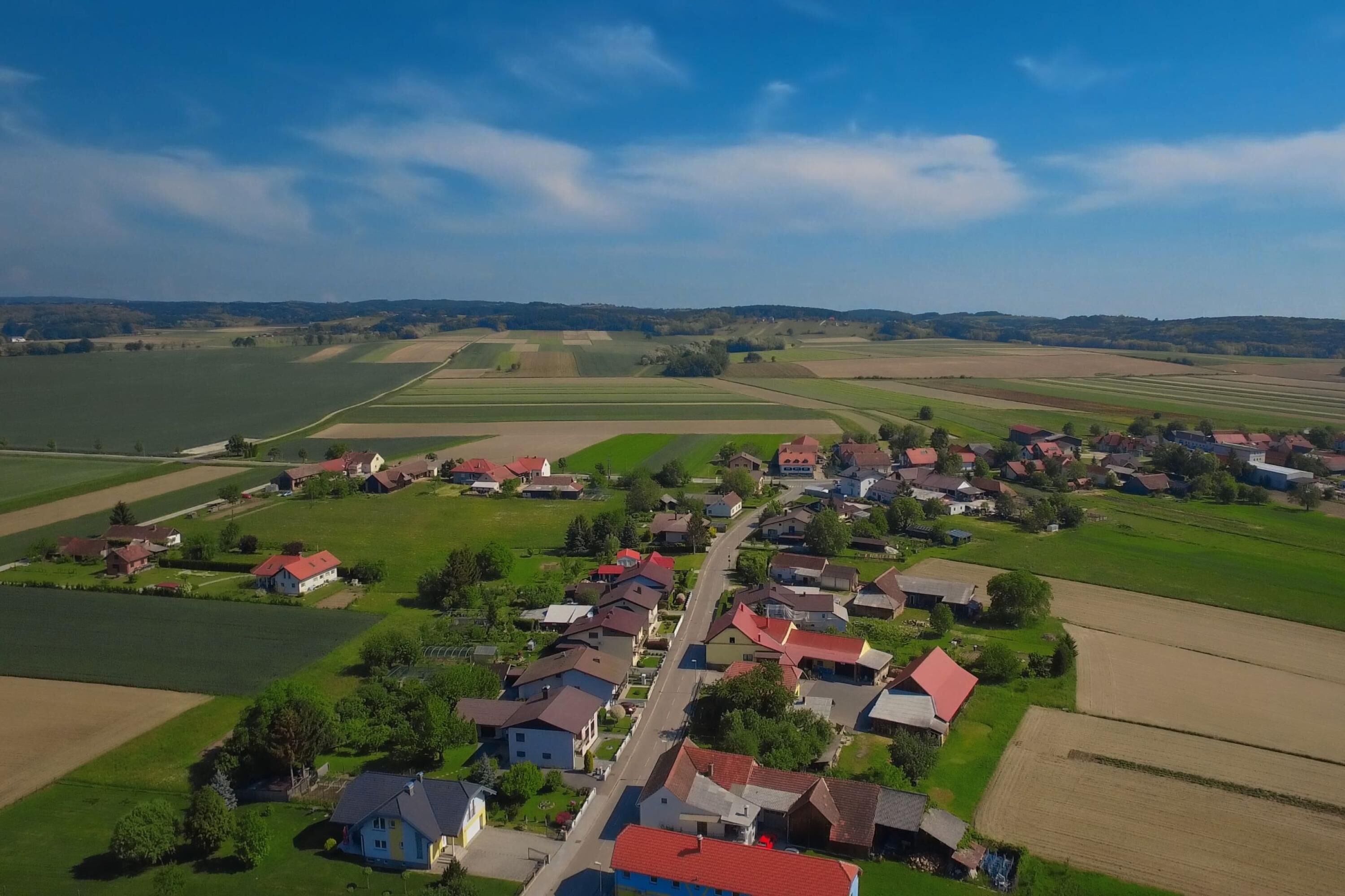 Luftaufnahme eines ländlichen Dorfes mit Häusern und Feldern.
