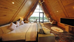 A cozy bedroom with a large bed, a sofa, a TV, and a view of the outdoors. - Rah Bagh (Srinagar)