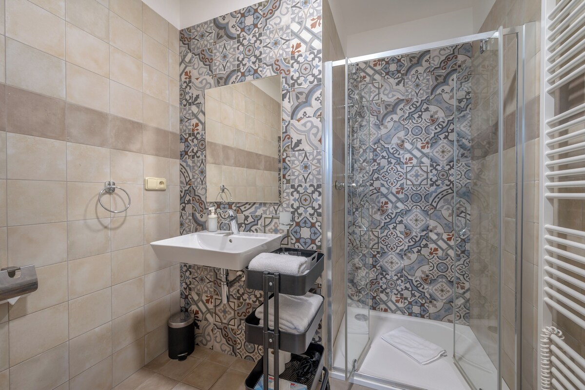 A bathroom with a shower, sink, and toilet.