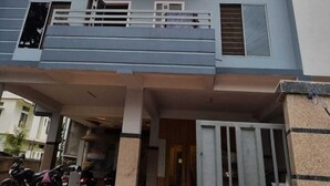 Un immeuble à plusieurs étages, sur lequel on peut lire l’enseigne « ALOHI INN », doté de balcons et présentant un design architectural moderne.