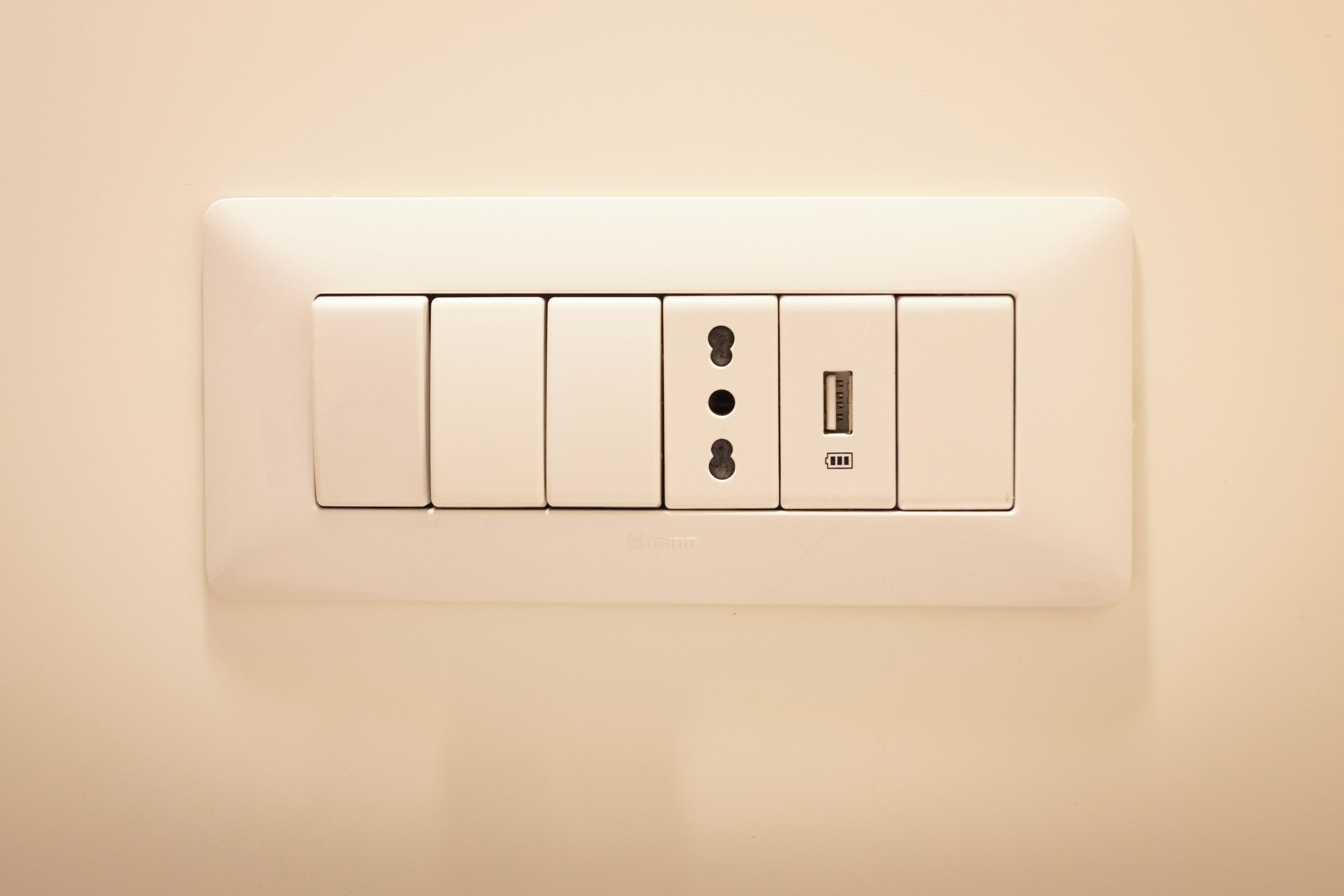 Een wandcontactdoos met vier stopcontacten, waaronder een USB-poort, en een schakelaar.