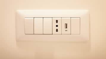 A wall-mounted electrical outlet with four sockets, including a USB port, and a switch.