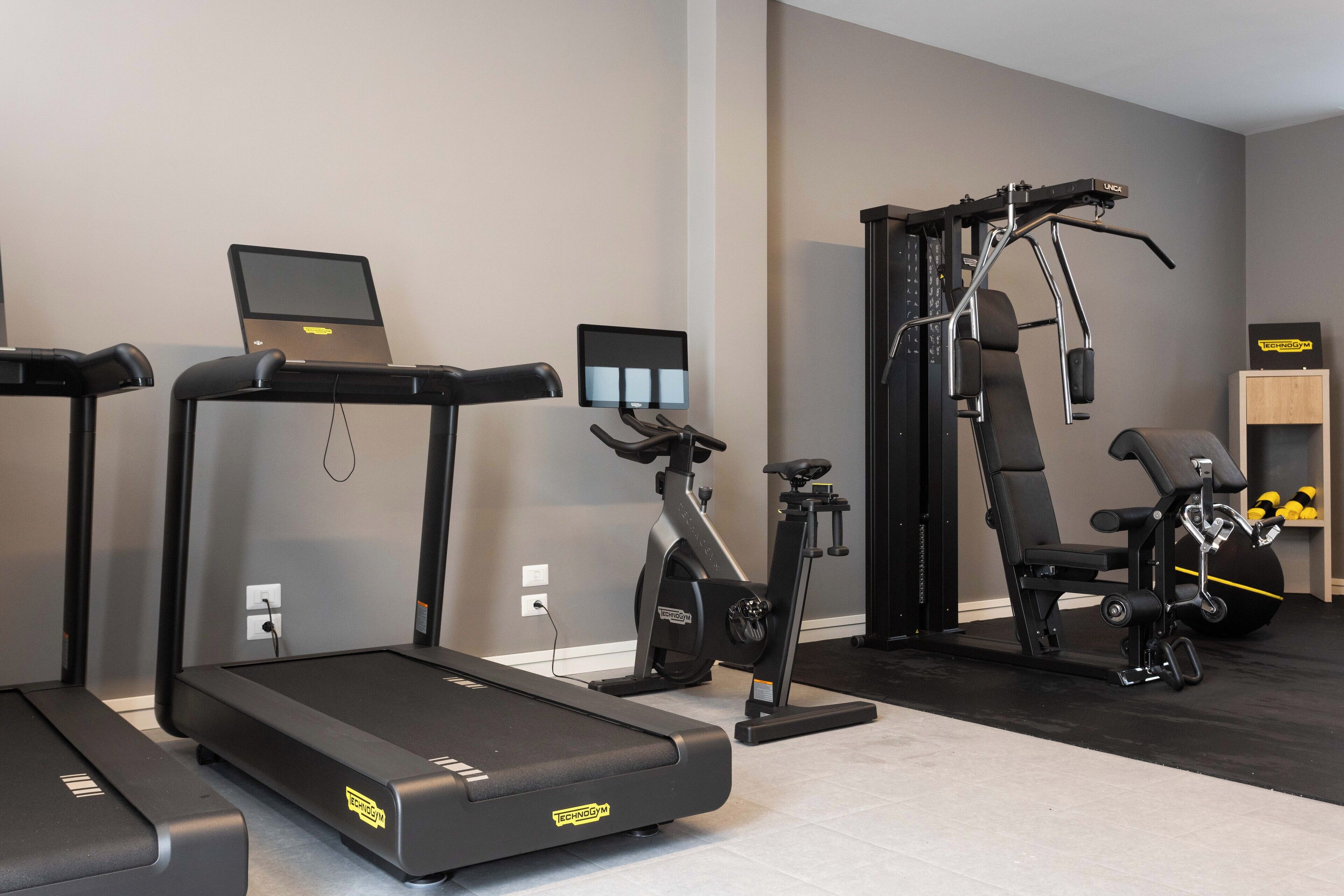 Un gimnasio con cintas de correr, elípticas y máquinas de pesas.