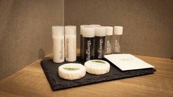 A display of BioEnergy products including bottles and cheese on a wooden surface.