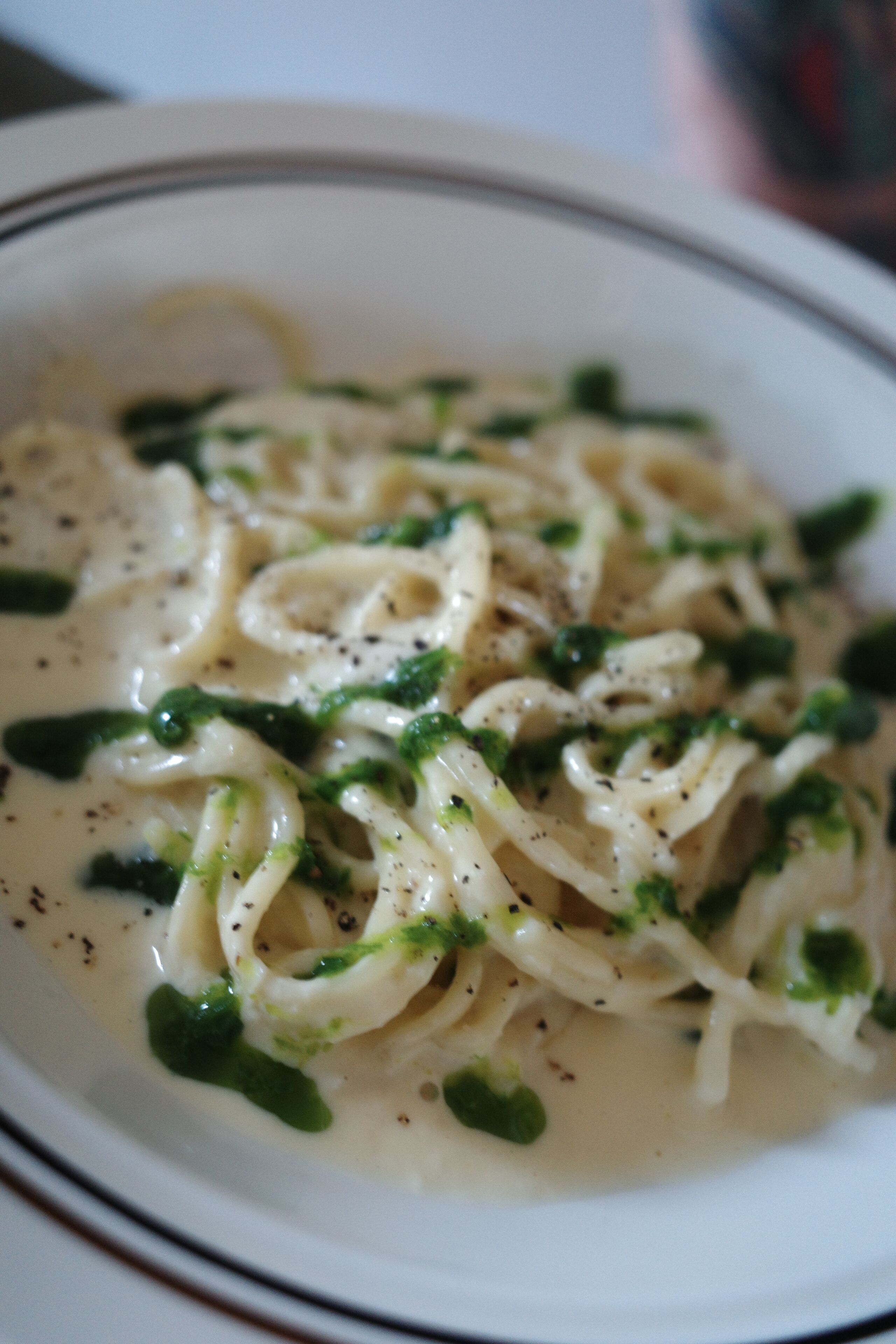 Un plato de pasta con salsa cremosa, adornado con hierbas.