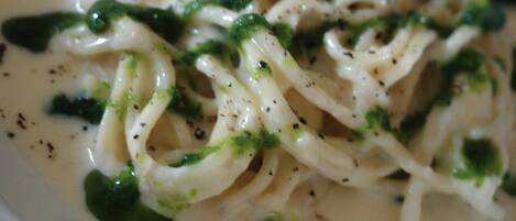 Un plato de pasta con salsa cremosa, adornado con hierbas.