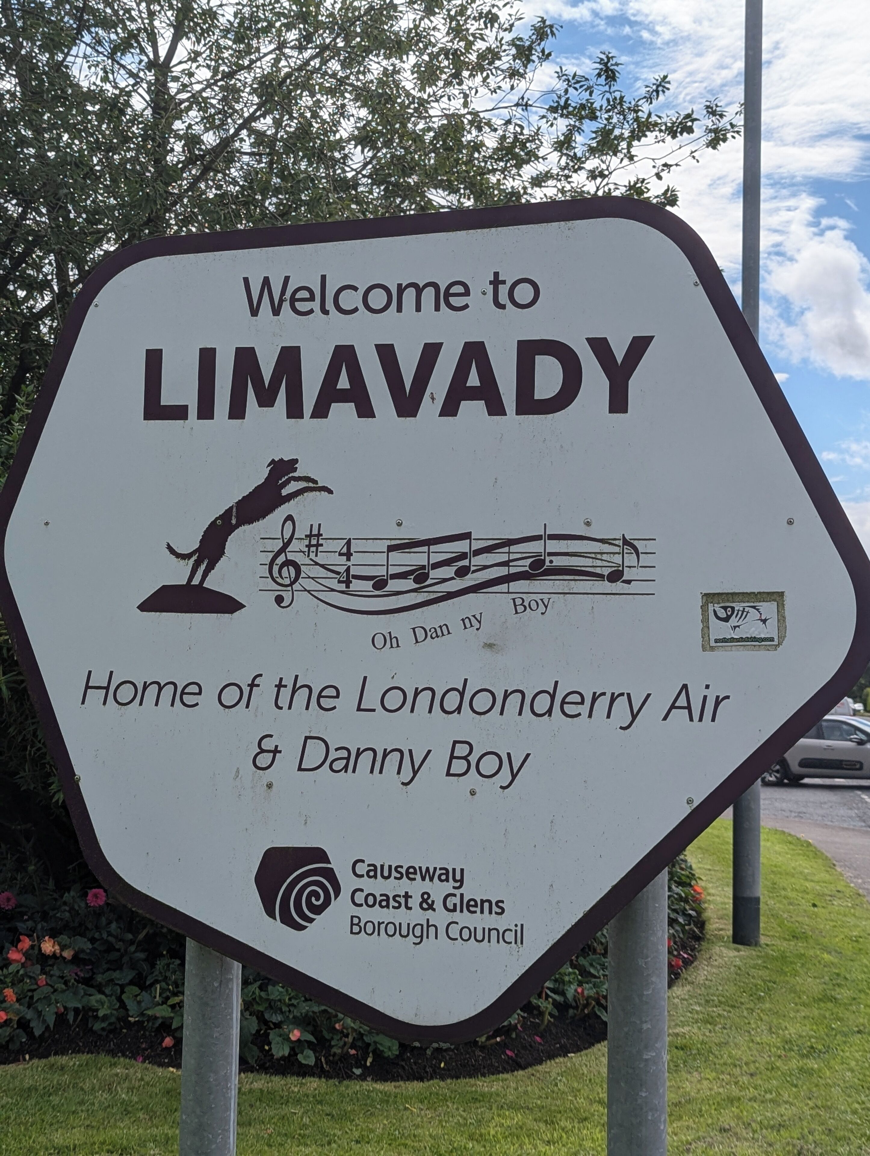 A welcome sign for LIMAVADY, featuring a musical note and a dancing figure, indicating a local attraction.