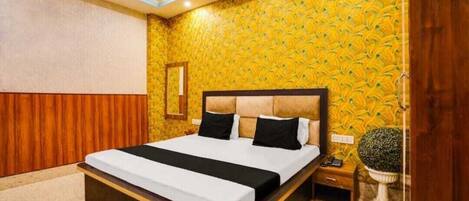 A modern hotel room with a large bed, wooden paneling on the walls, and a patterned wallpaper.