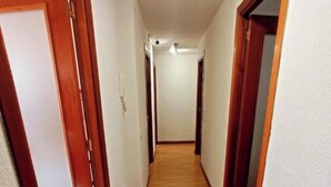 A narrow hallway with wooden flooring and white walls. - Posada Madrileña (Madrid)