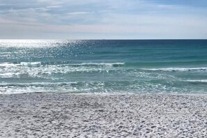A beach with waves and a clear sky.