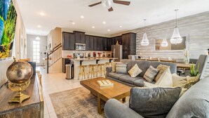 A modern living room with a sofa, coffee table, and a globe on a side table. - Luxury Solara House W/ Pool  Near Disney (Kissimmee)