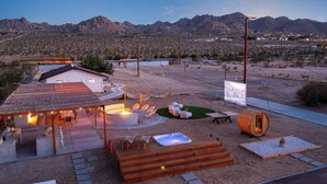 Un complexe hôtelier situé dans le désert, doté d’un espace extérieur aménagé, d’un jacuzzi et d’une terrasse en bois.