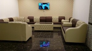 Una sala de estar moderna con un conjunto de sofá, una mesa de centro y un televisor de pantalla plana montado en la pared.