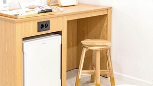 A compact wooden desk with a built-in mini-fridge and a stool. - hotel77 (Chuncheon)