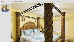 A four-poster canopy bed with a headboard, a bedside table, and a nightstand.