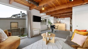 Ein modernes Wohnzimmer mit Holzboden, einem runden Couchtisch und einem grauen Sofa.
