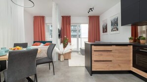 A modern apartment with a dining area, kitchen, and living space.