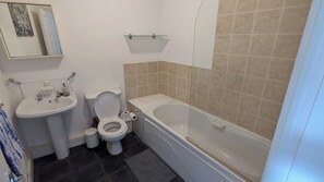 Un baño con inodoro, lavamanos y bañera.