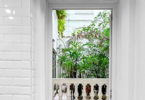 Een witte deur met een balkon, plantenbakken en een witte balustrade.