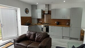 Una cocina moderna con gabinetes grises, una estufa a gas y una cafetera.